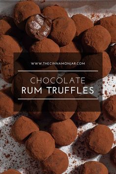 Homemade rum truffles on a white tray, dusted in cocoa powder.