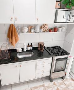 a kitchen with white cabinets and black counter tops