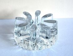 an ice sculpture with spoons in it on a white tableclothed surface,