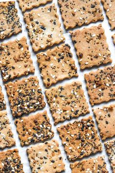 square crackers with sesame seeds and sea salt on top, lined up in rows