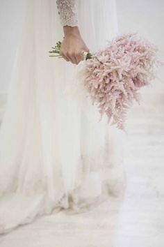 a bride holding a bouquet of flowers in her hand