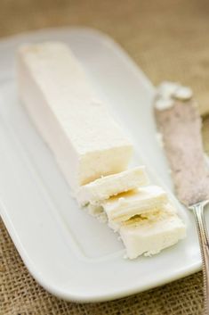 a white plate topped with sliced bananas next to a spoon