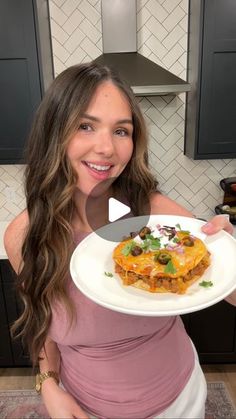 a woman holding a plate with food on it