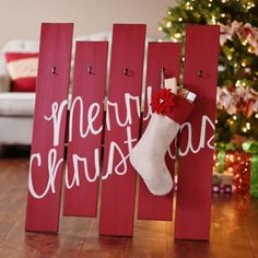 a christmas stocking hanging on the side of a wooden sign