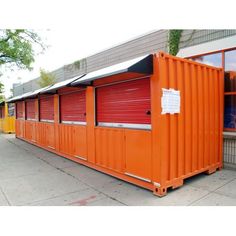 several orange storage units lined up on the sidewalk