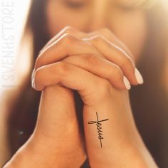 a woman's wrist tattoo with the word love written on it and a cross in the middle