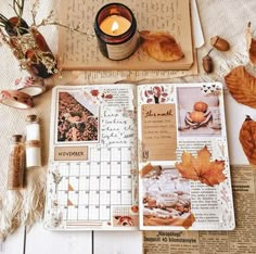 an open book with pictures and leaves on it next to a candle, jar of cinnamons