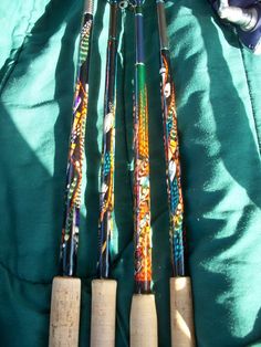 four different types of baseball bats laying next to each other on a green cloth covered surface