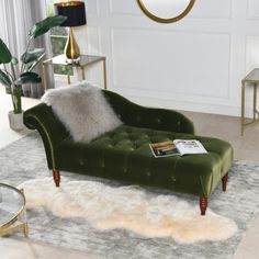 a green velvet chaise lounge chair in a living room with white carpet and gold accents