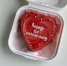 a heart shaped cake in a white box with the words happy 1st anniversary written on it