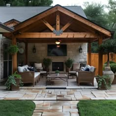 an outdoor living area with couches, chairs and a fire place in the center