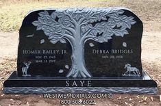 a black headstone with an animal and tree on it in the middle of a field