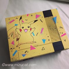 an old nintendo game console with a pikachu design on the front and side