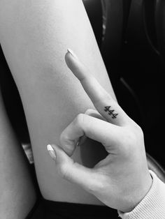 a person with a tattoo on their arm pointing to the left side of her body