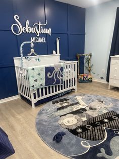 a baby's room with blue walls and white furniture, including a crib