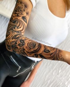 a woman with a rose tattoo on her arm and sleeve is posing for the camera