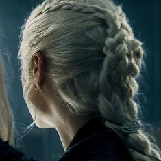 two women with blonde hair and braids looking into each other's eyes