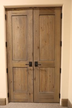 two wooden doors in a room with carpeting