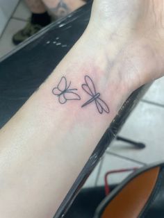 a small dragonfly tattoo on the wrist