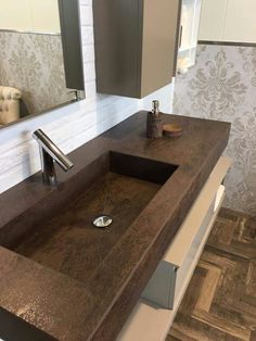 a bathroom sink sitting on top of a wooden counter