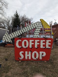 a red sign that says coffee shop with polka dots on the top and an arrow pointing up