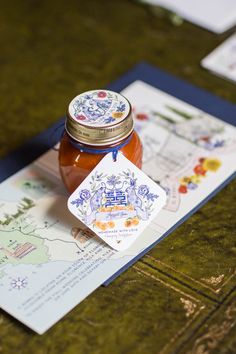 a jar of honey sitting on top of a map next to a card and envelope