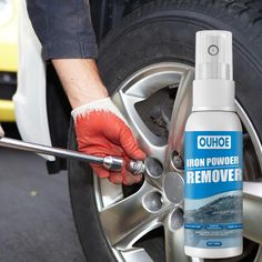 a man holding a wrench next to a tire with an iron powder remover on it