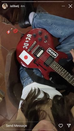 a person laying on the floor with a red guitar