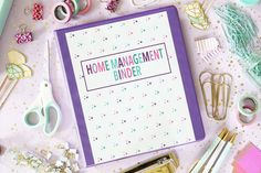 a binder with the words home management binder surrounded by craft supplies and scissors