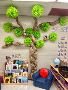 a classroom decorated with green tissue pom poms and a tree on the wall