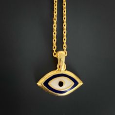 The Dainty Evil Eye Necklace is perfect for you if you're looking for something simple to wear every day. This beautiful necklace features a small evil eye charm on a sterling silver chain and will brighten your day with its protective energy and bring you good luck. This necklace comes in a silver and a 18k gold plated variant. The Dainty Evil Eye Necklace also has a matching bracelet and earrings. The Evil Eye bead is a prominent symbol in Turkish and many other cultures, and is highly protect Symbolic Yellow Gold Evil Eye Necklace, Symbolic Evil Eye Yellow Gold Necklace, Good Luck Pendant Jewelry With Delicate Chain, Good Luck Pendant With Delicate Chain, Evil Eye Amulet Pendant Jewelry, Yellow Gold Evil Eye Spiritual Necklace, Symbolic Evil Eye Round Pendant Necklace, Spiritual Yellow Gold Necklace With Evil Eye, Spiritual Yellow Gold Evil Eye Necklace