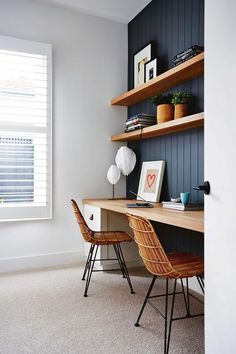 a desk with two chairs next to it in front of a window and bookshelf