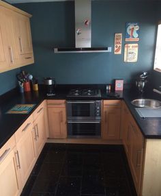 a kitchen with black counter tops and wooden cabinets