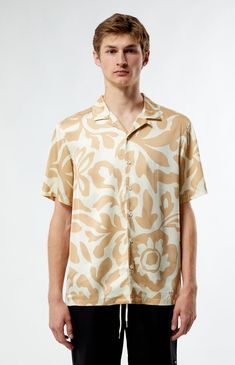 PacSun's Mari Tan Camp Shirt is a your go-to for laid-back sophistication. With its collared neckline, short sleeves, and regular fit, this shirt offers a timeless silhouette. Complete with button closures and a lightweight feel, its print throughout adds a touch of intrigue to your casual ensemble.


	Collared neckline
	Short sleeves
	Standard fit
	Button closures
	Custom pattern
	100% Rayon
	Machine washable
	Model is wearing size medium
	Model Measurements: 6'1.5” Height, 28” Waist, 32” Inseam Pacsun Mens, Camp Shirt, Camping Shirt, Shirt Price, Exclusive Collection, Model Measurements, Pacsun, Cool Style, Top Shirt