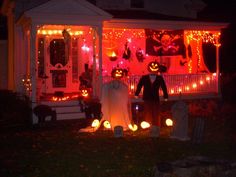 two people dressed up in halloween costumes standing on the front porch of a house decorated for halloween