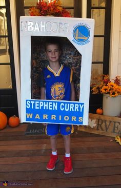 a young boy holding up a sign with the image of stephen curry in front of him