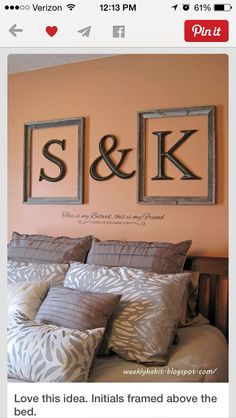 a bed with two framed pictures above it and the word s & k on the wall