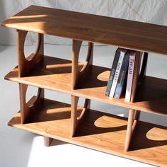 a wooden shelf with books and magazines on it's sides, against a white background