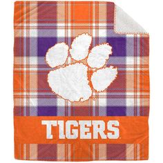 an orange and white plaid blanket with the word tigers on it, in front of a white background