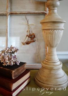 two books are sitting on a table next to a vase with flowers and a book