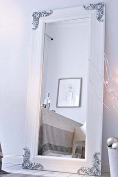 a white mirror sitting on top of a tiled floor