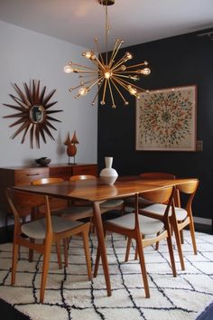 a dining room table with chairs and a chandelier hanging from it's ceiling