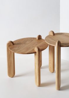 two wooden stools sitting next to each other on top of a white flooring