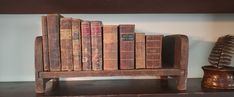 an old wooden bench with many books on it