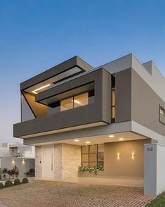 a modern house with an open floor plan and large windows on the top level is shown at dusk