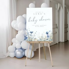 a baby shower sign with balloons in the background