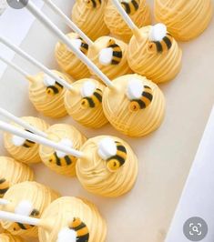 honeybee cupcakes with white and yellow frosting are arranged on a tray