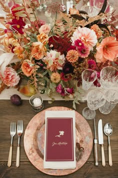 a table setting with place settings, silverware and flowers in the centerpieces