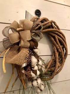 a wreath with cotton and burlocks hanging on the wall