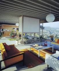 a living room with couches, chairs and tables in front of a large window